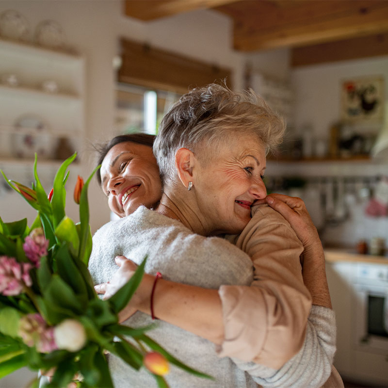 adult daughter hugging her mother with dementia